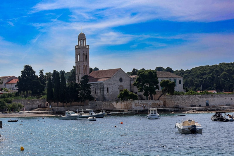 boats are in the water in front of a church